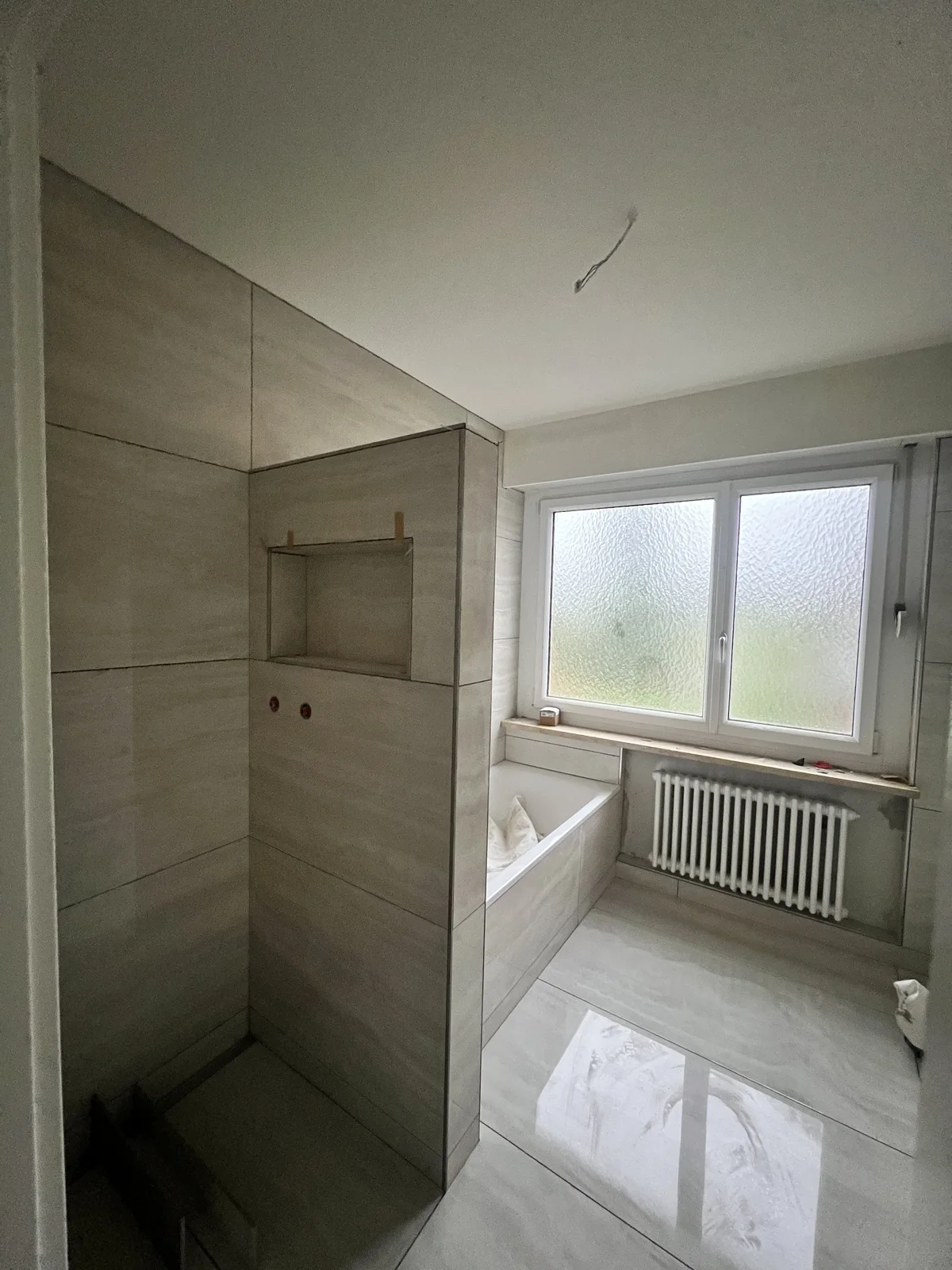 Wand- und Bodenplatten mit Duschnische und Badewannenverkleidung